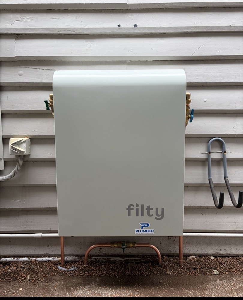 Filty whole-home filtration unit installed on a weatherboard home