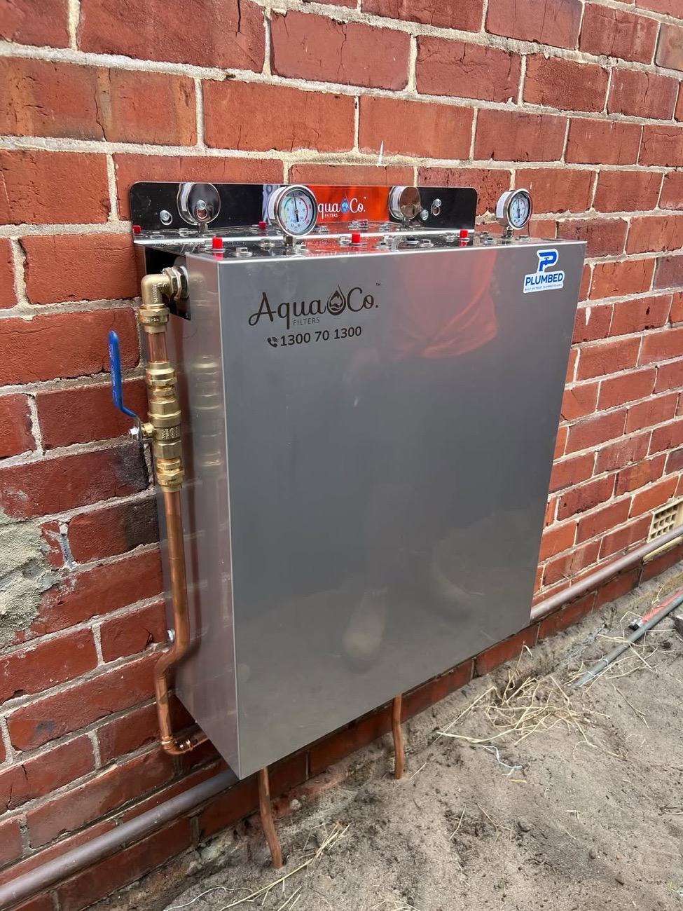 Whole-home filtration unit installed on a brick wall